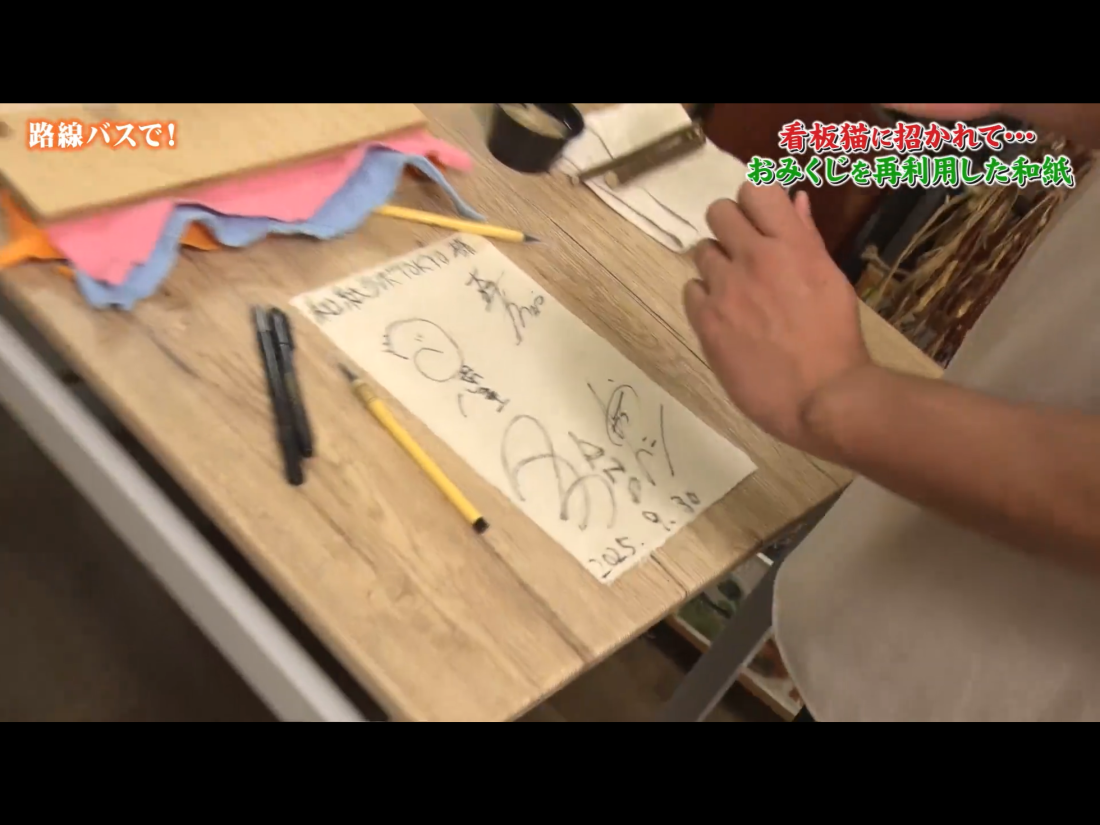 和紙にサインを書く出演者